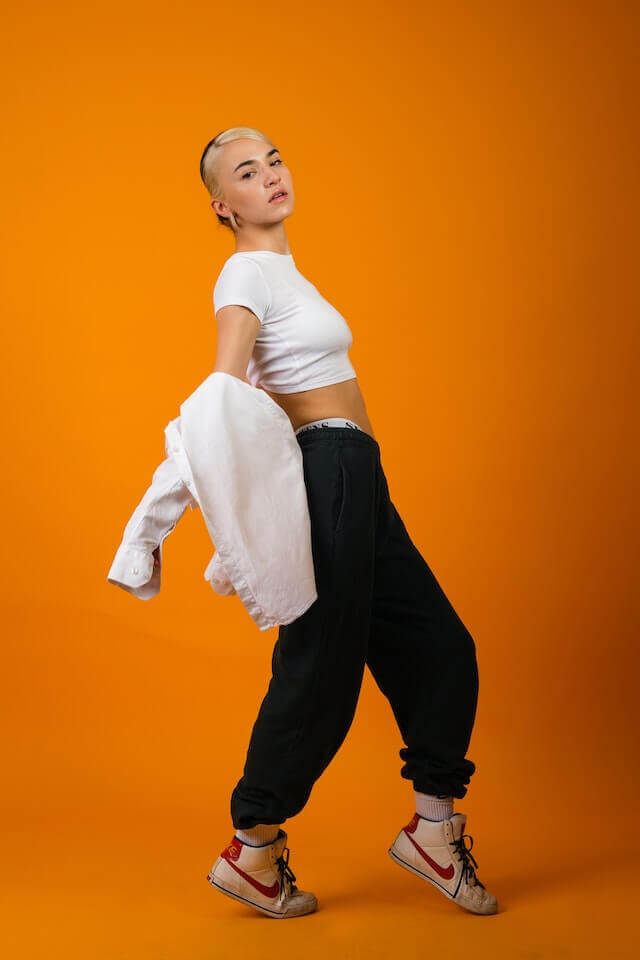 female model posing bending backwards with orange background